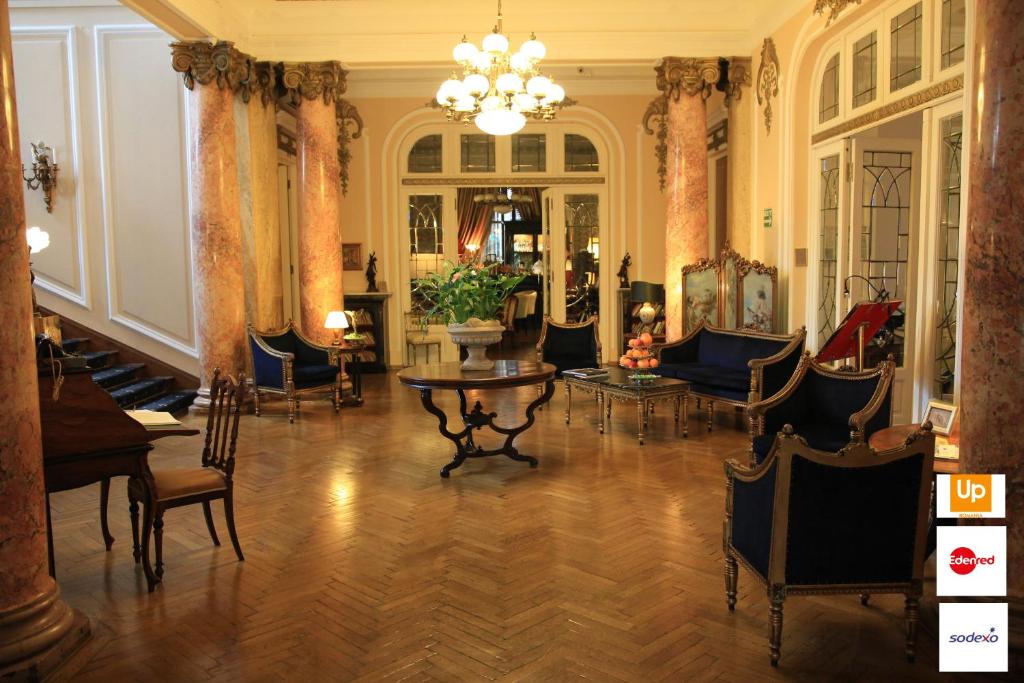 a living room with chairs and a table and a chandelier at Grand Boutique Hotel in Bucharest
