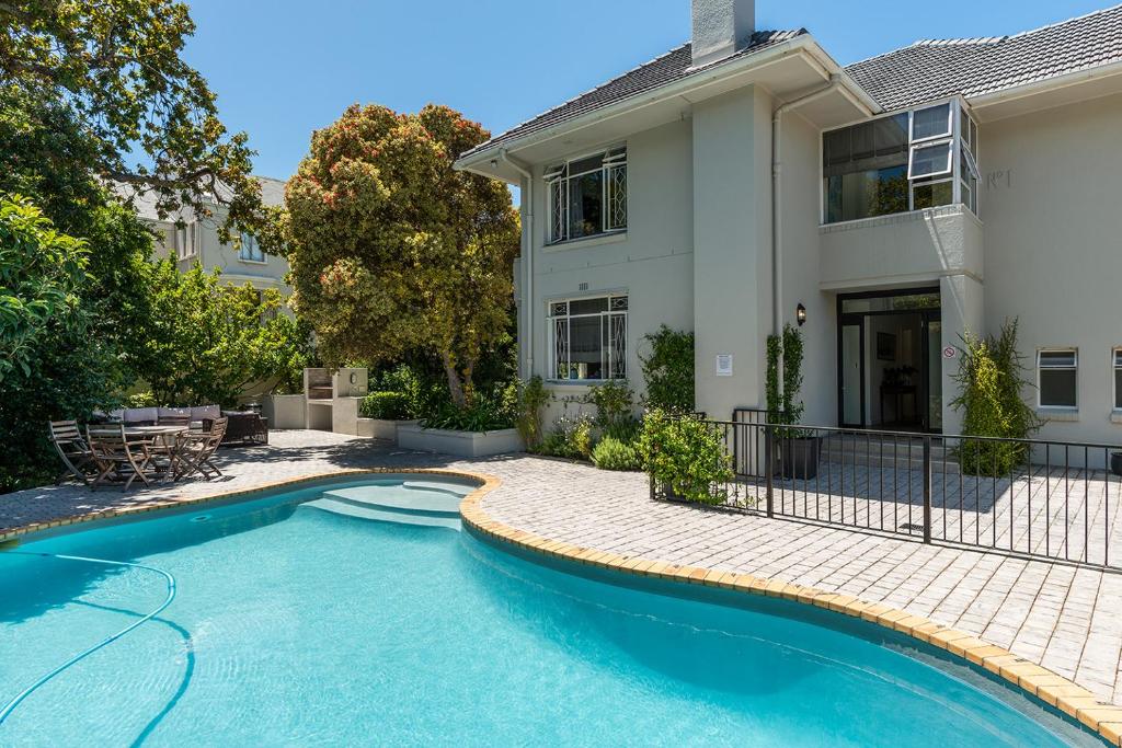 a swimming pool in front of a house at Oak Manor in Cape Town