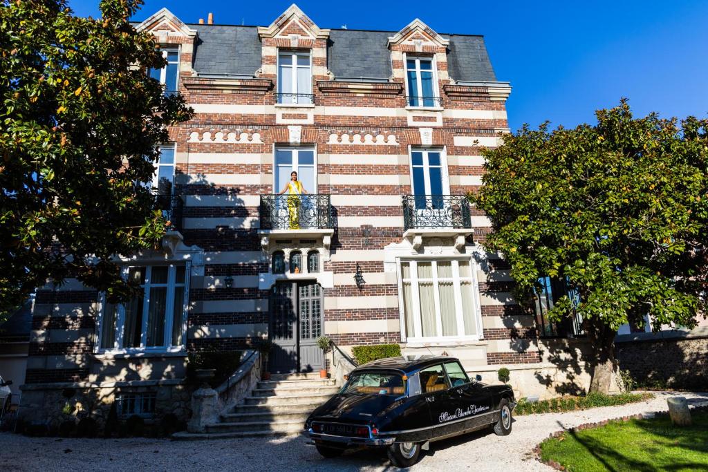 een zwarte auto geparkeerd voor een gebouw bij Maison Blanche Chartres - Maison d'hôtes 5 étoiles in Chartres