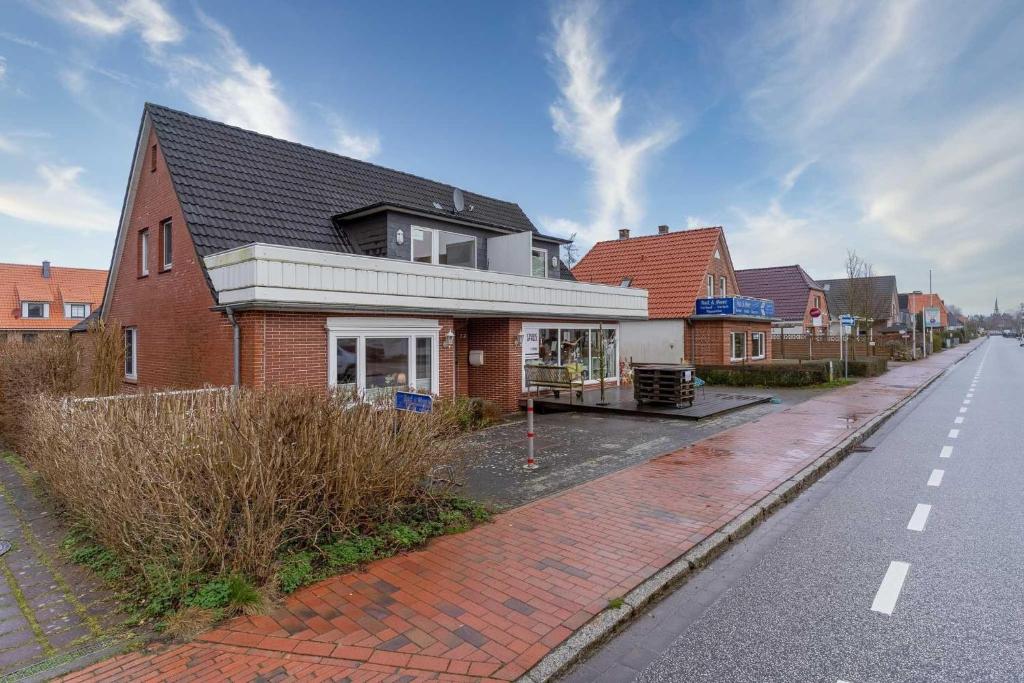 een rood bakstenen huis aan de kant van een straat bij Haus-Springfloot-Whg-2-OG in Olsdorf