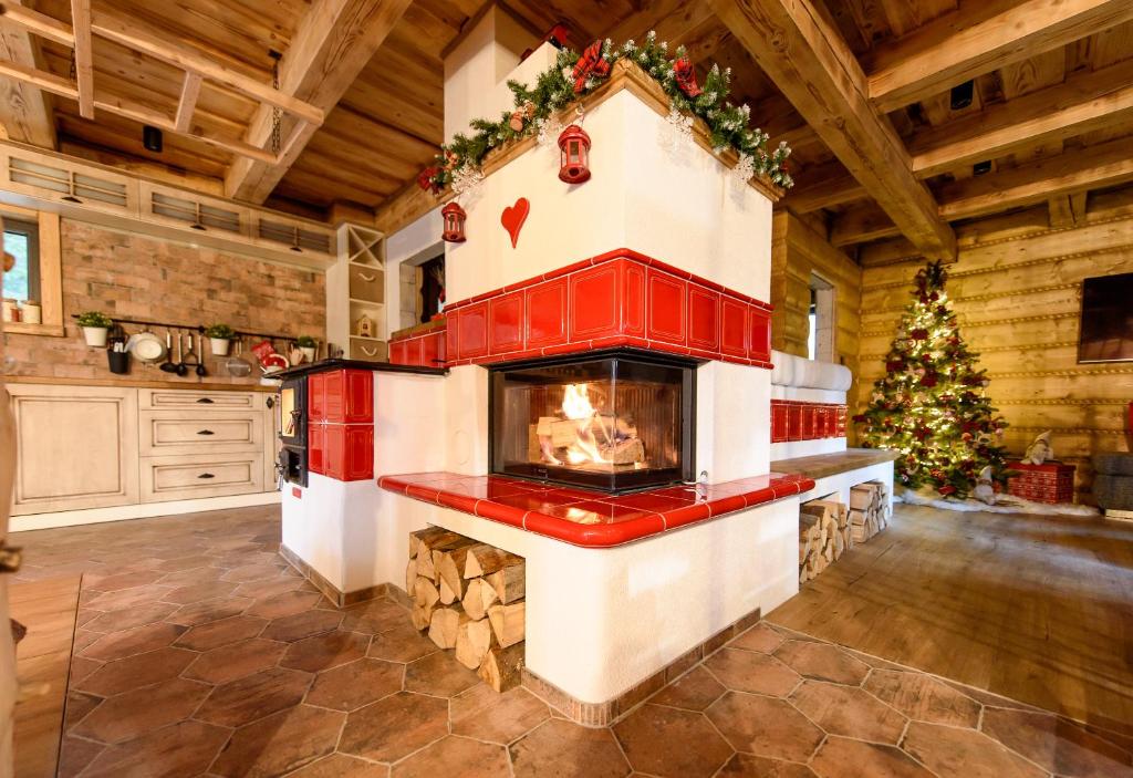 a fireplace in a kitchen with a christmas tree at ZRUB MARTINKY in Demanovska Dolina