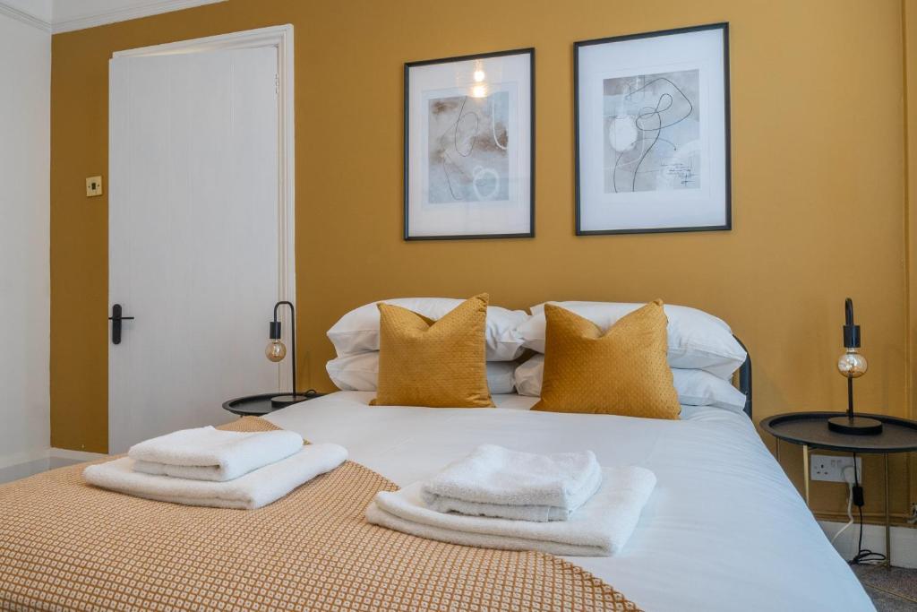 Un dormitorio con una cama blanca con toallas. en South View - 3 bed modern Chester house - Close to city centre, en Chester