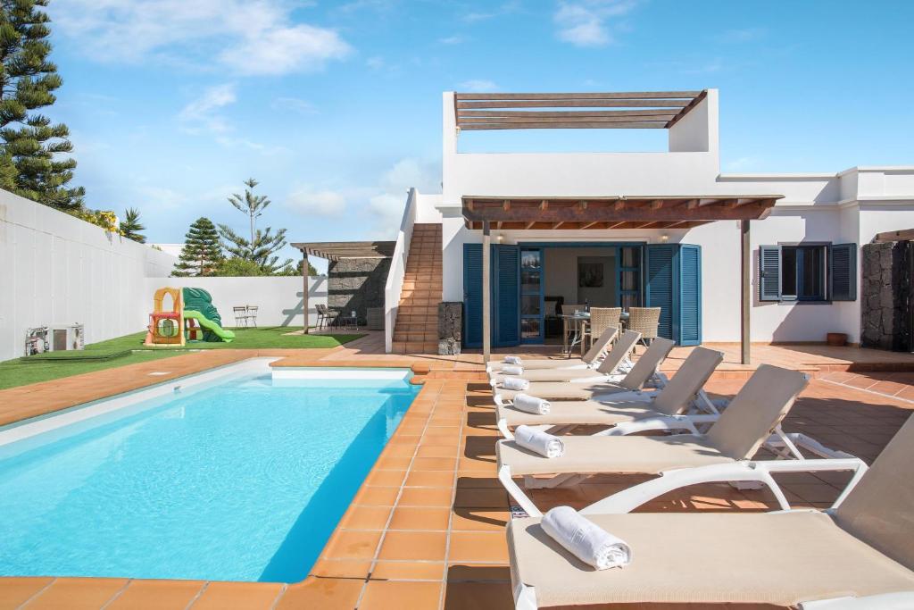 szereg leżaków przy basenie w obiekcie Villa Alegranza w mieście Playa Blanca