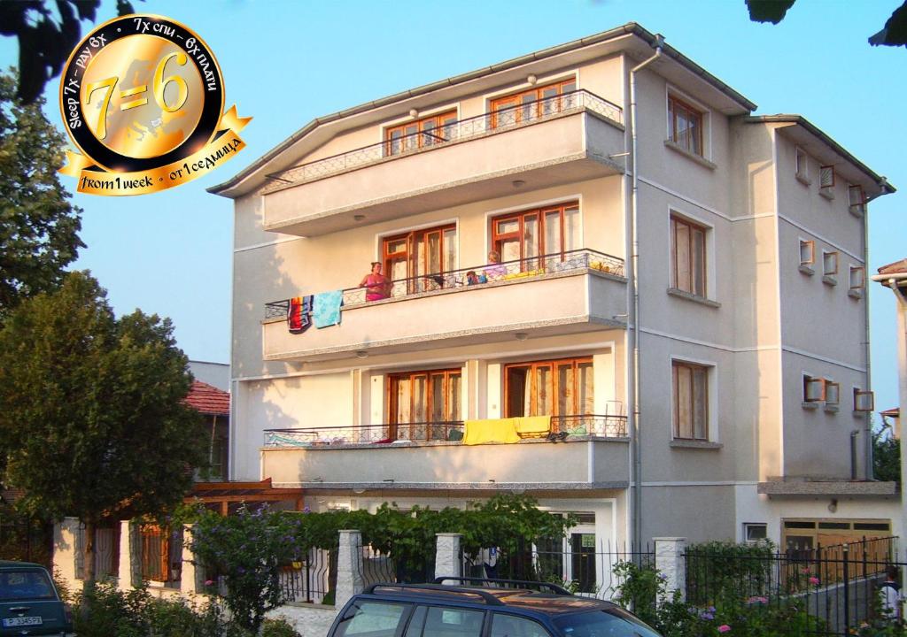 a white building with a car parked in front of it at Pension Dicev in Obzor