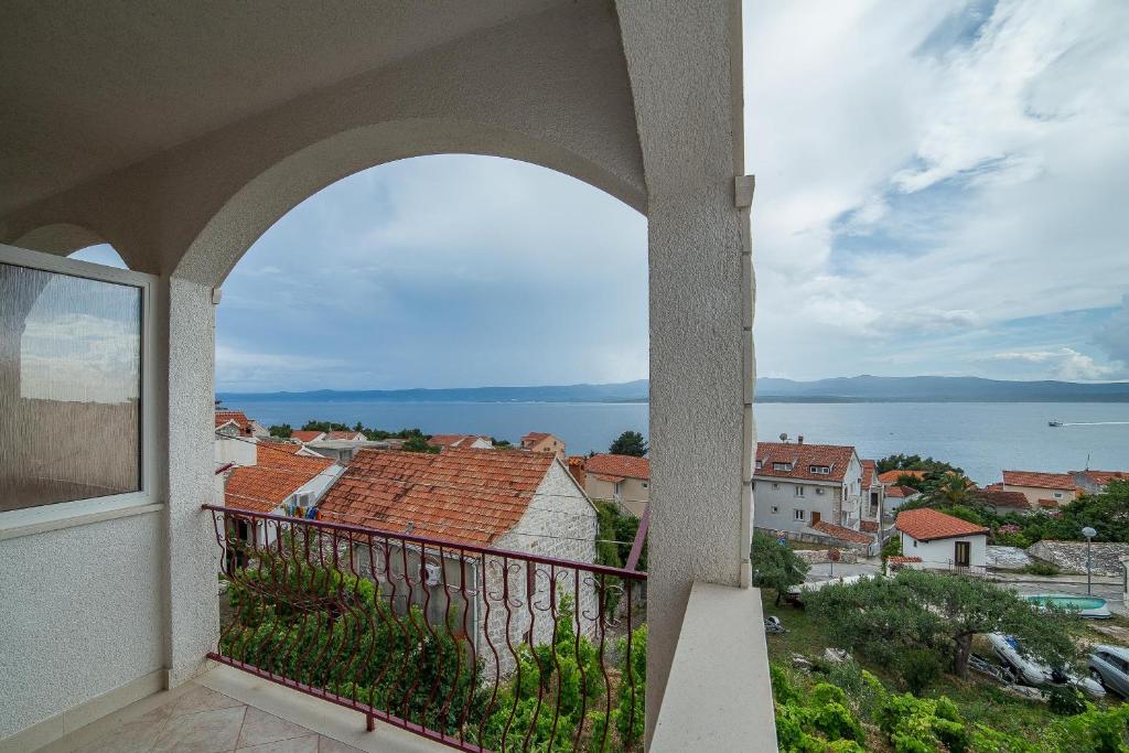 balcón con vistas al agua y a los edificios en Apartments Brižić, en Bol