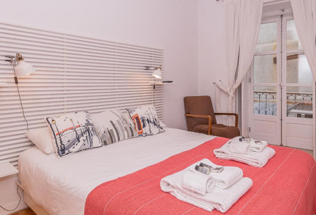 a bedroom with a bed with towels on it at Alfama Comfy Premium Apartment in Lisbon