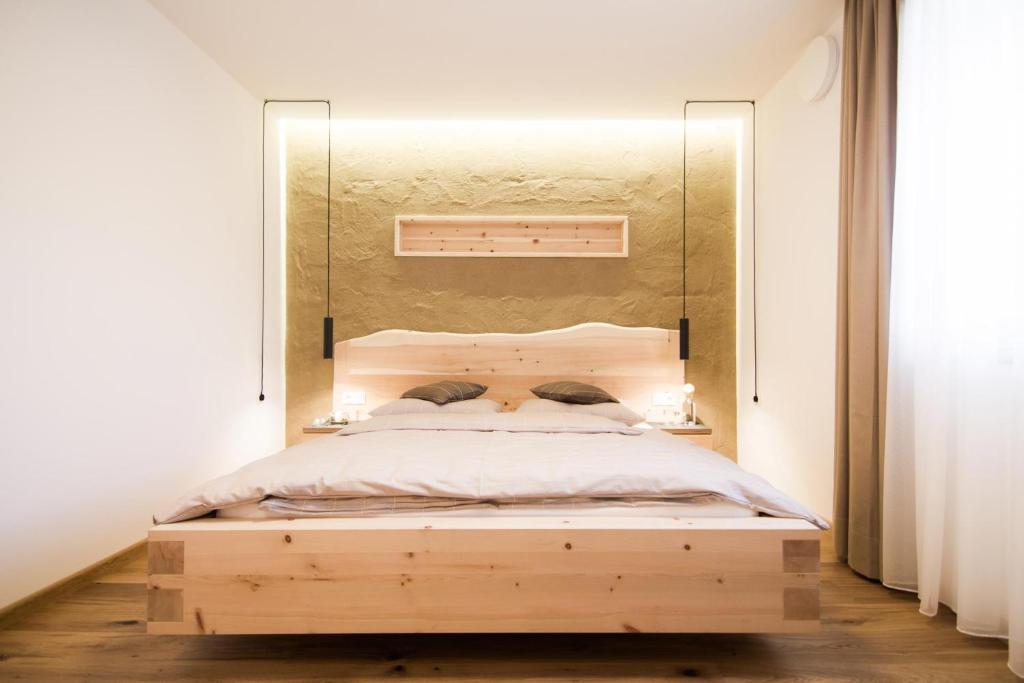 una camera con letto in legno e specchio sopra di esso. di haus urban B&B a Barbiano