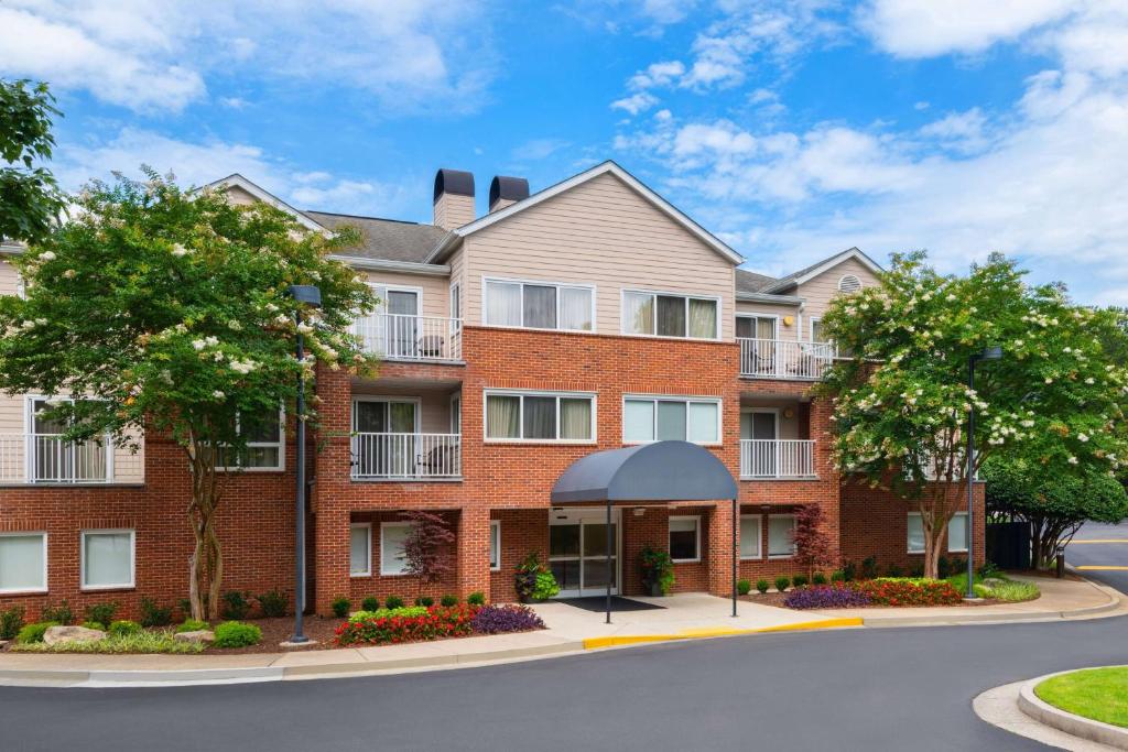 duży ceglany budynek z drzewami przed nim w obiekcie Sonesta ES Suites Atlanta Alpharetta Windward w mieście Alpharetta