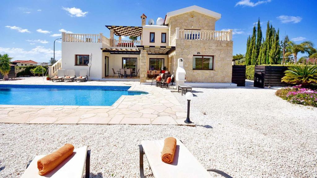 a villa with a swimming pool in front of a house at Villa Cleco in Coral Bay