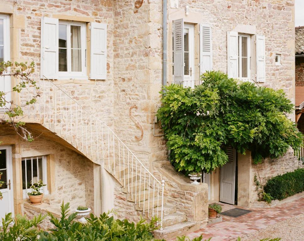 - un bâtiment en pierre avec des escaliers sur son côté dans l'établissement MA CHAMBRE A SAINT AMOUR, à Saint-Amour-Bellevue
