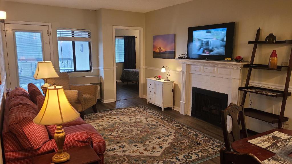 a living room with a fireplace and a tv at Gatlinburg Chateau Condo 506 in Gatlinburg