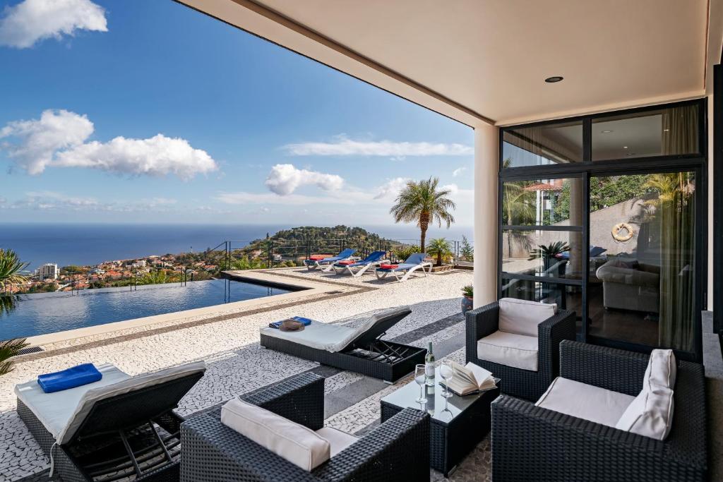 d'une terrasse avec vue sur l'océan. dans l'établissement Exquisite Madeira Villa Villa Funchal Luz 5 Bedroom Heated Pool Sea Views Games Room Fu, à Funchal