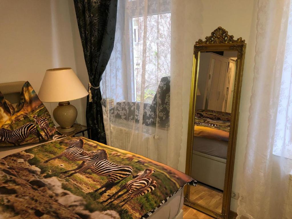- une chambre avec un lit, un miroir et une lampe dans l'établissement Flair and Design Apartment!, à Vienne