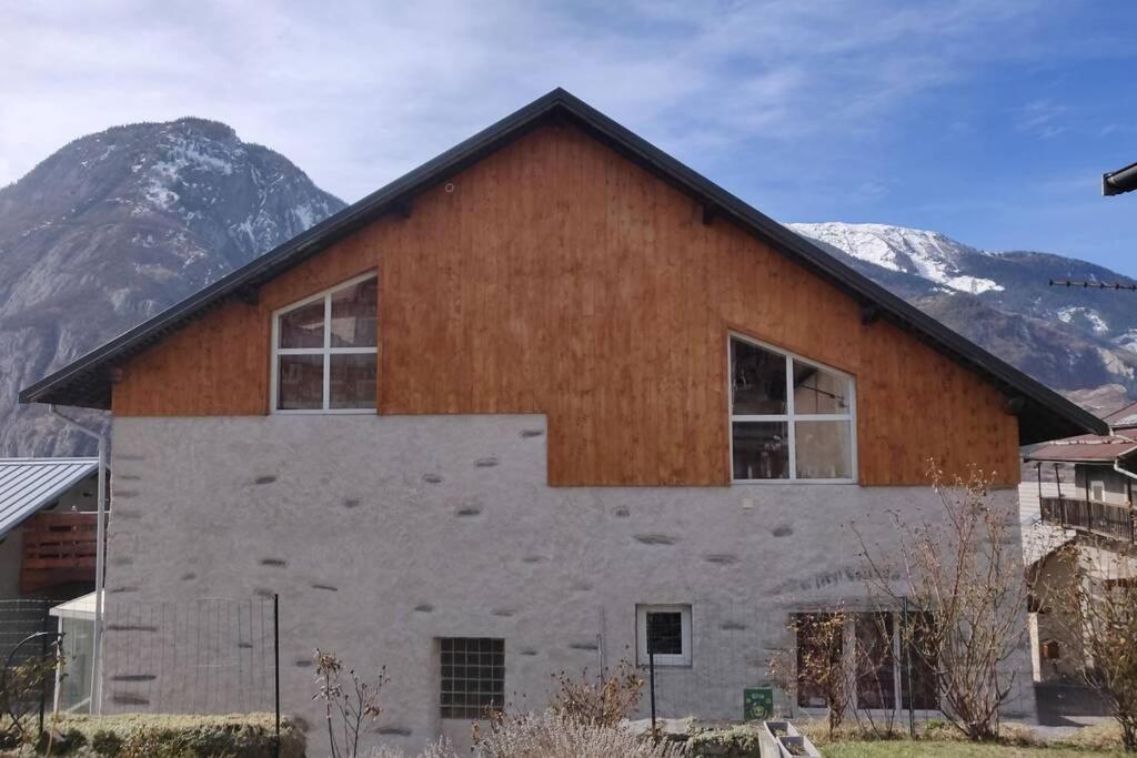 a barn with a mountain in the background at gîte patou et joel 6 personnes in Saint-Martin-de-la-Porte