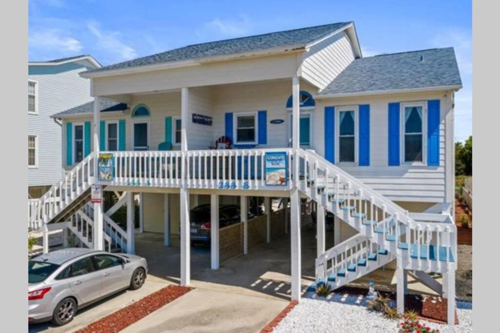 a blue and white house with a porch and a car at Aqua Haven - Second Street from Beach Home in Holden Beach