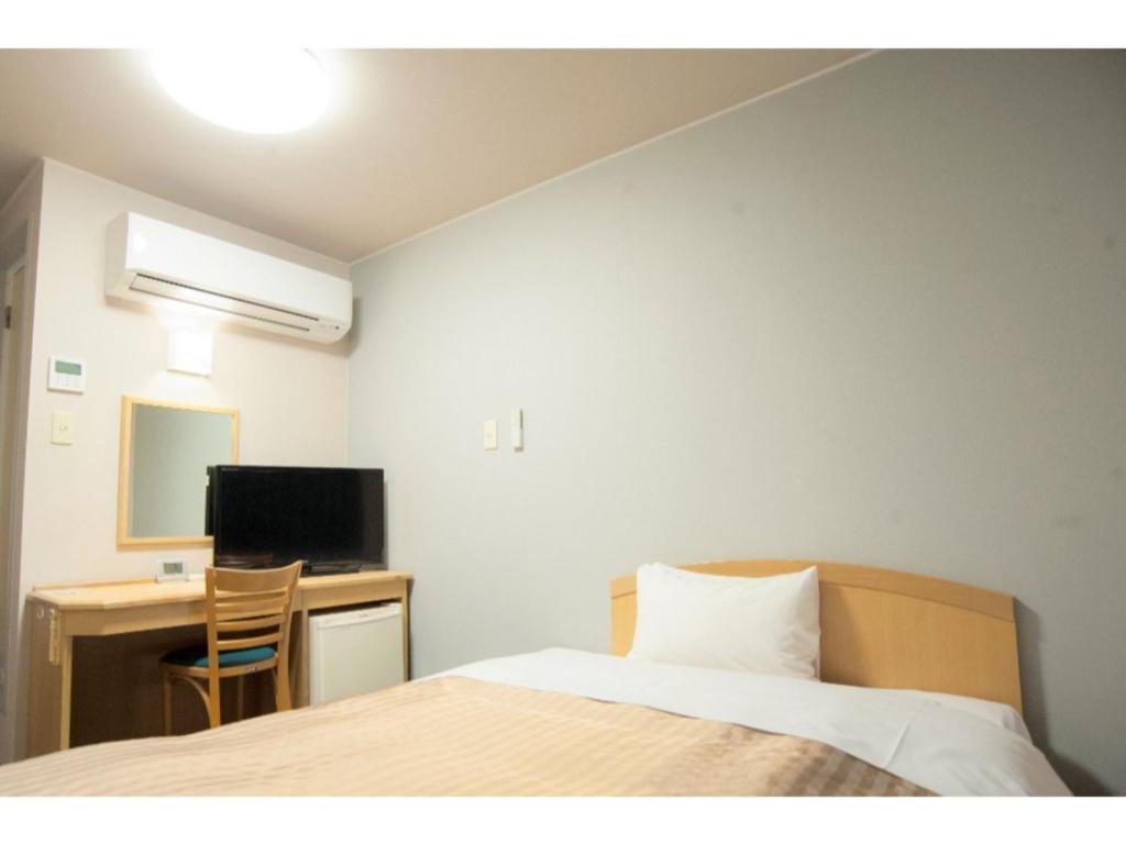 1 dormitorio con 1 cama y escritorio con ordenador en Fujieda Ogawa Hotel - Vacation STAY 20866v en Fujieda