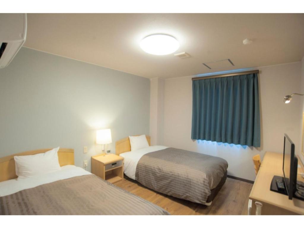 Habitación de hotel con 2 camas y ventana en Fujieda Ogawa Hotel - Vacation STAY 20873v en Fujieda