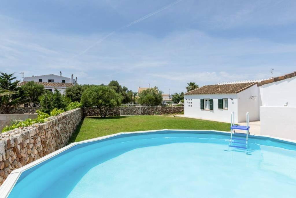 a villa with a swimming pool and a house at Chalet Signe Cranc in Sa Caleta