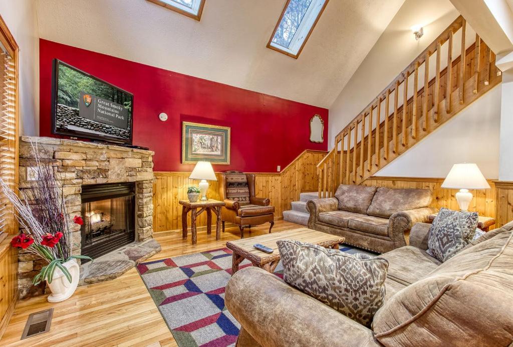 a living room with a couch and a fireplace at Brentwood, Resort Pool, FREE Attraction tickets, Near Parkway, Hot Tub, Arcade Game, WIFI!!! in Pigeon Forge