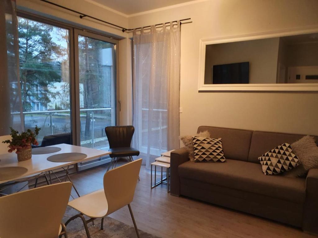 - un salon avec un canapé et une table dans l'établissement Baltic Blue Apartamenty Pobierowo, à Pobierowo