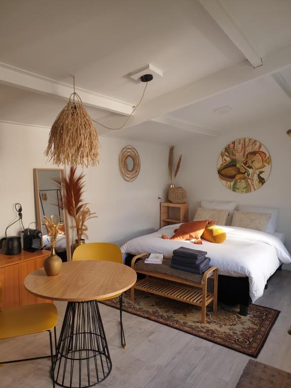 um quarto com uma cama, uma mesa e cadeiras em Little Lodge Noordwijk aan Zee em Noordwijk