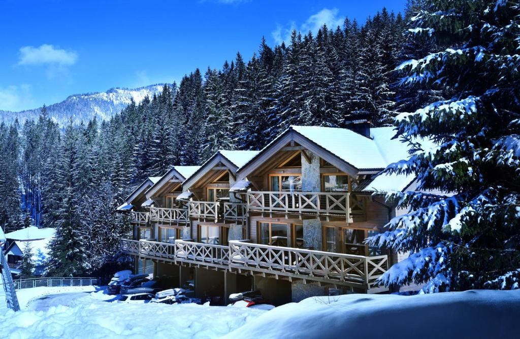 un lodge en la nieve con árboles nevados en Chalet Jasná Wellness Apartment Maxim jacuzzi & sauna en Demanovska Dolina
