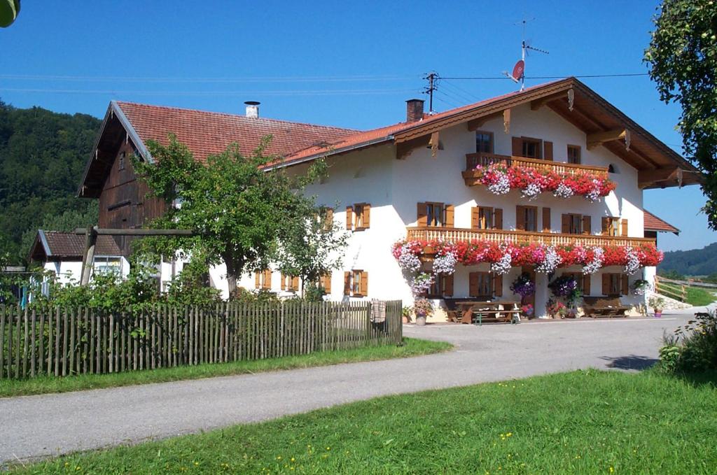 a white house with flowers on the balcony at Stöcklhof in Siegsdorf