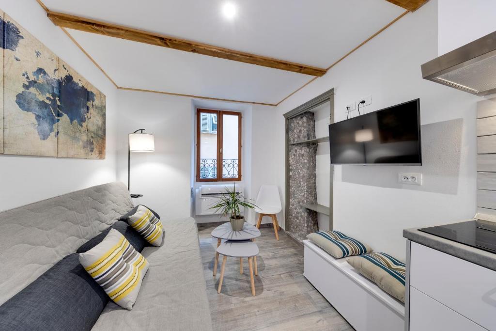 sala de estar con sofá y TV en Duplex des Sablettes, en Menton