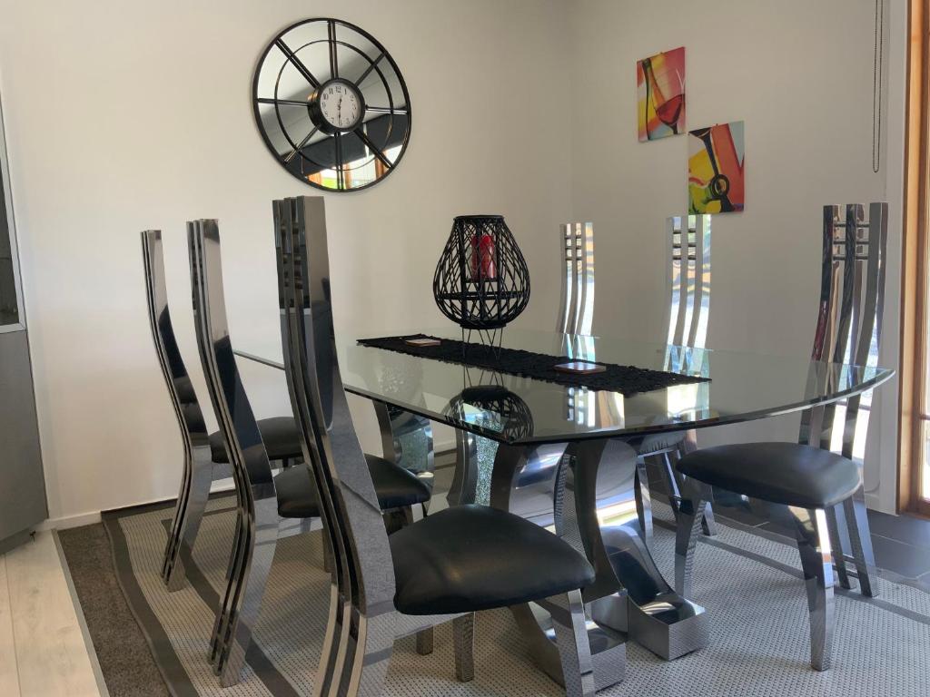 a dining room with a glass table and chairs at A Cut Above Lodge - The Gateway to the Bay of Islands in Kerikeri