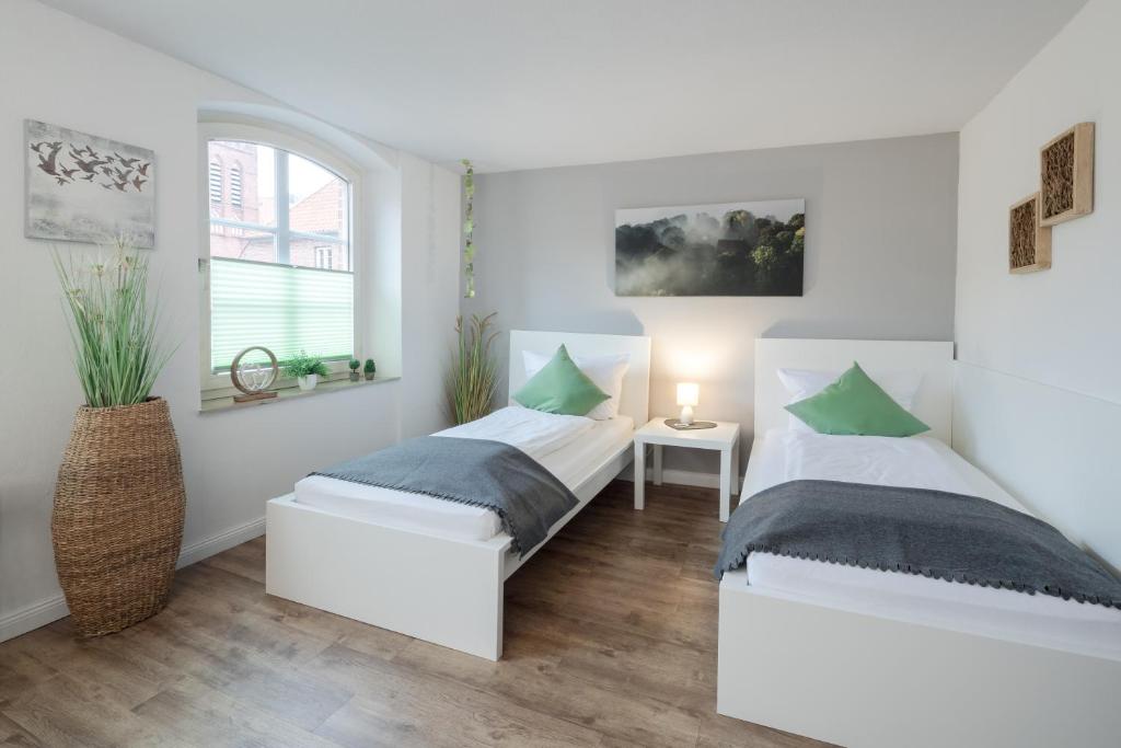 two beds in a room with white walls at Gästehaus Von Herzen in Lauenburg