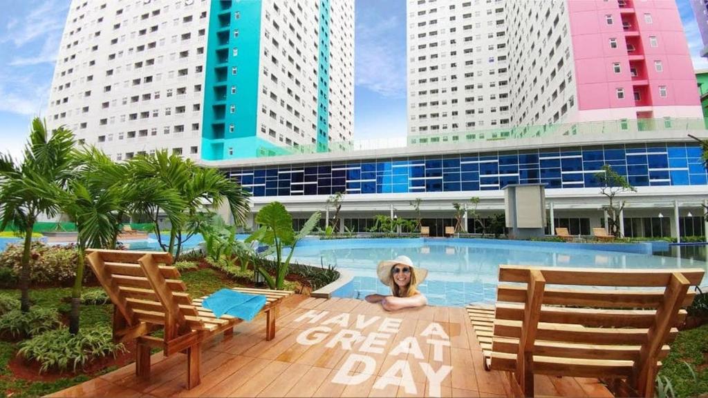 a sign that says leave a great day in front of a swimming pool at Properti9 at Apartemen Green Pramuka in Jakarta