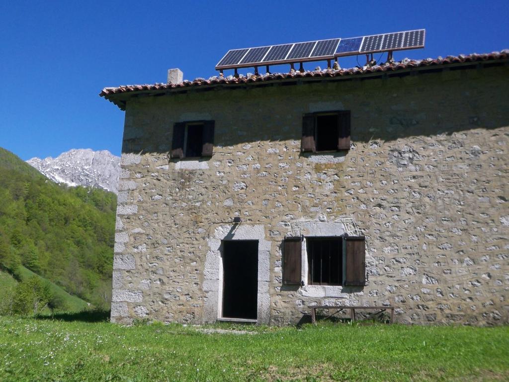 un antiguo edificio de piedra con paneles solares en el techo en Venta la Aurora en Beleño