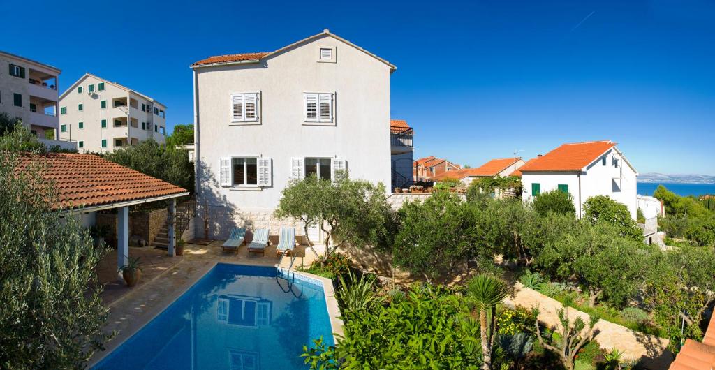 a house with a swimming pool in front of a building at Holiday Home Lukrecia in Supetar