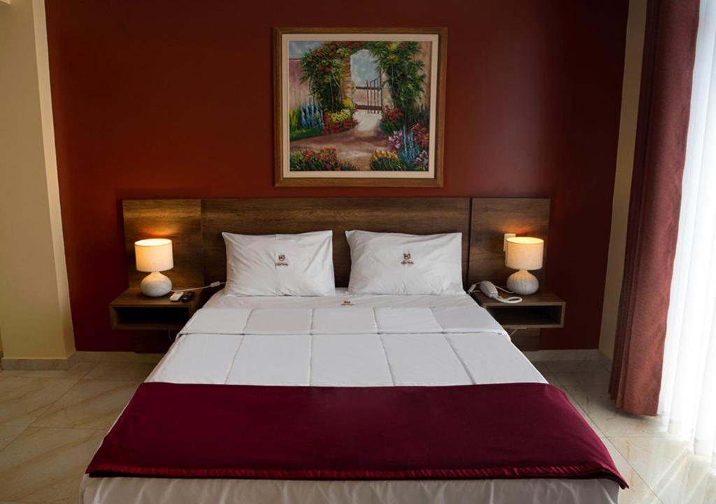 a bedroom with a large bed with two lamps at Hotel Central in Trujillo