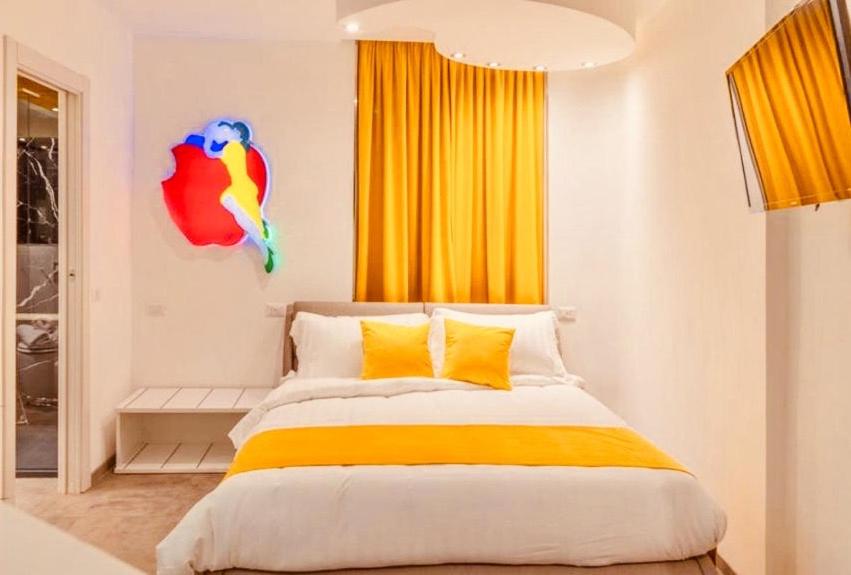 a bedroom with a large bed with yellow curtains at Governo Vecchio Guesthouse Navona in Rome