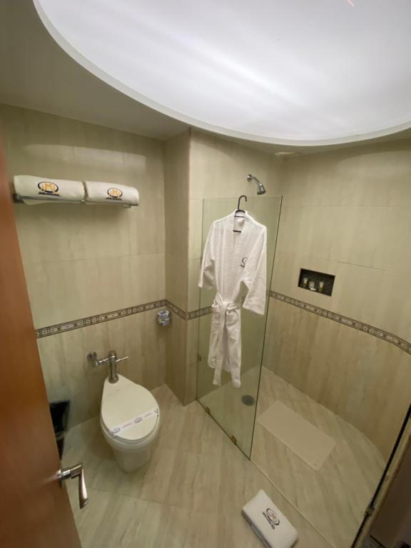 A compact tiled bathroom with a glass-enclosed shower and toilet.