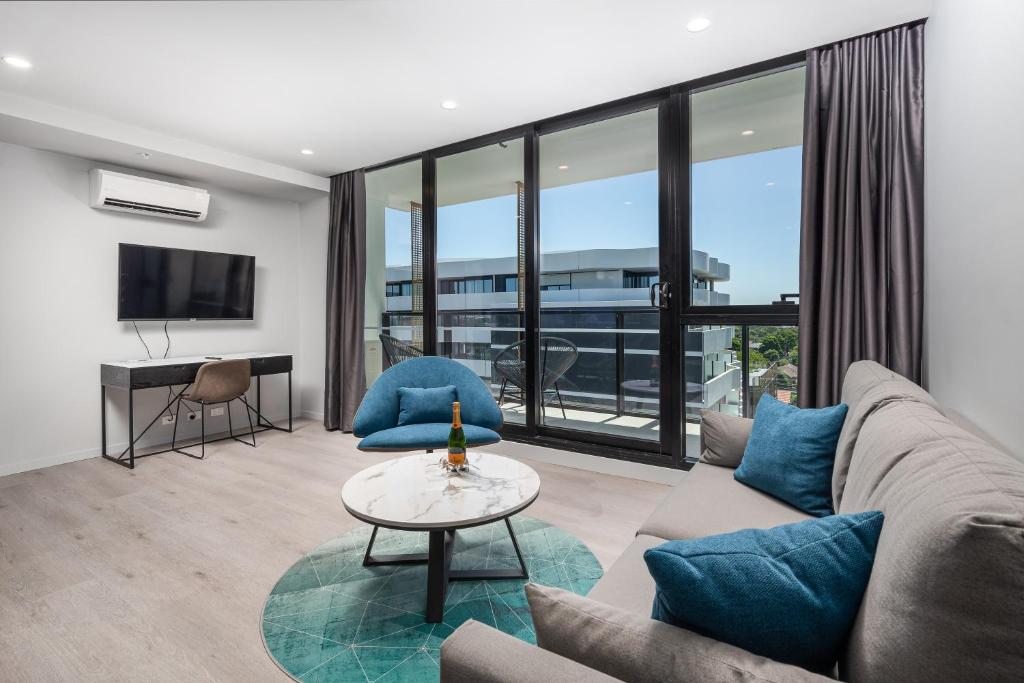 a living room with a couch and a table at Oros Hotel and Apartments in Oakleigh