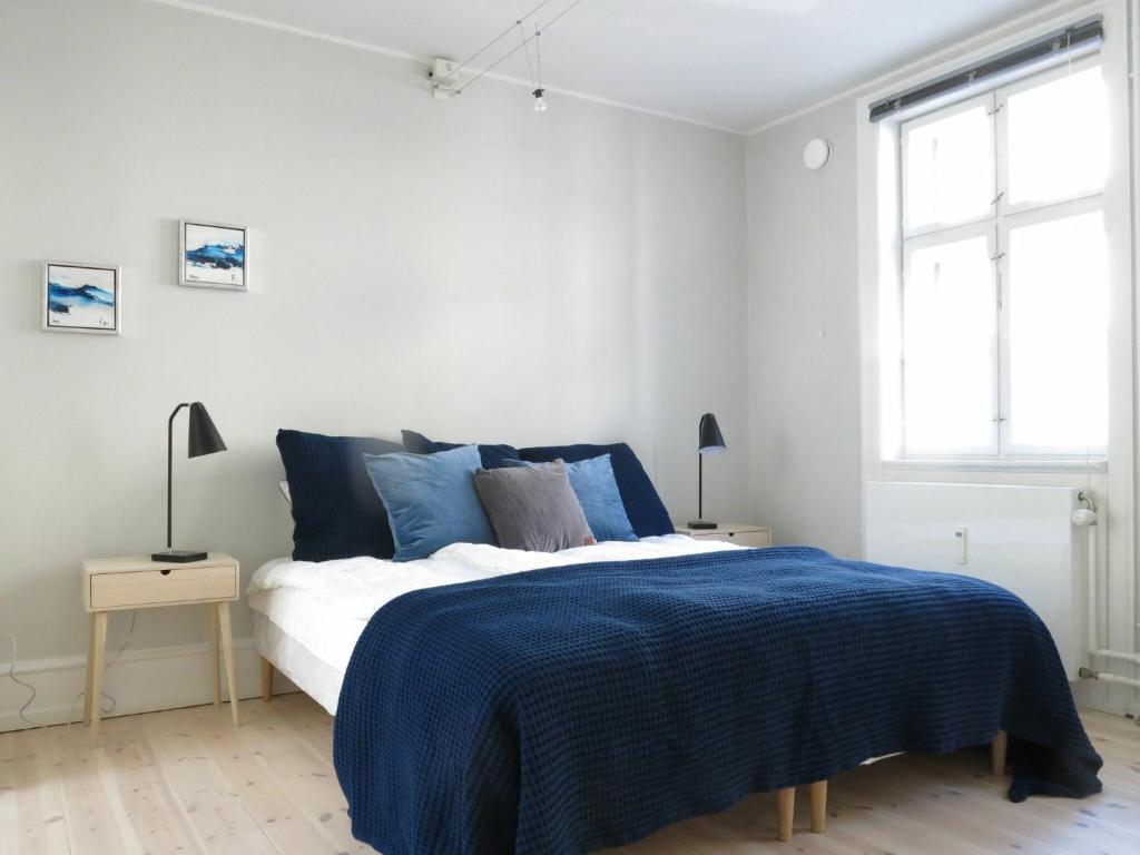 コペンハーゲンにあるApartmentInCopenhagen Apartment 1142のベッドルーム1室(青い毛布付きのベッド1台付)