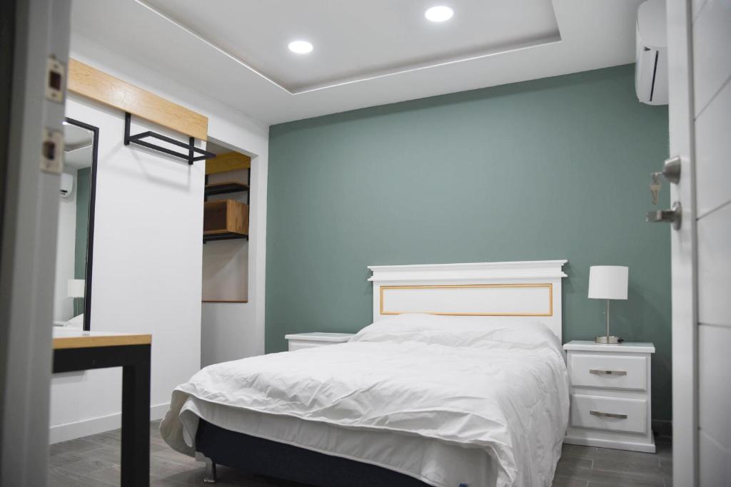 a bedroom with a white bed and a desk at Casa moderna equipada como hotel Habitación 1 in Monterrey