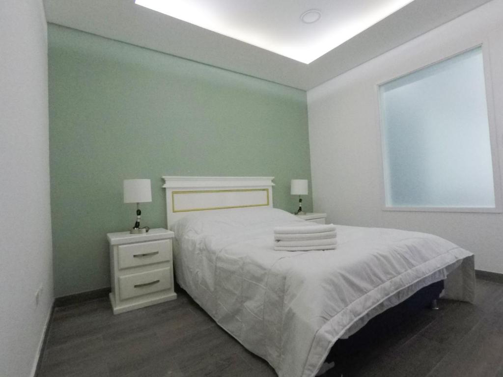 Dormitorio verde con cama y ventana en Casa moderna equipada como hotel Habitacion 3 - baño afuera de la habitación en Monterrey