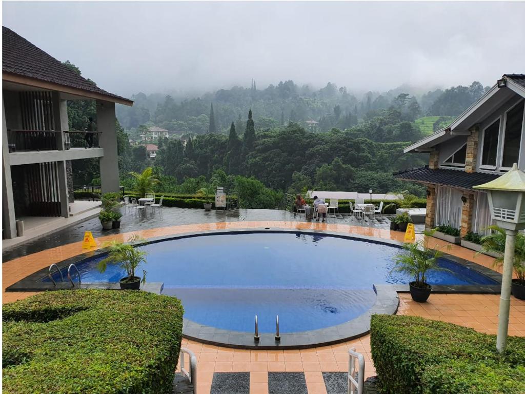 a large swimming pool in the middle of a house at Hotel Ariandri Puncak in Puncak