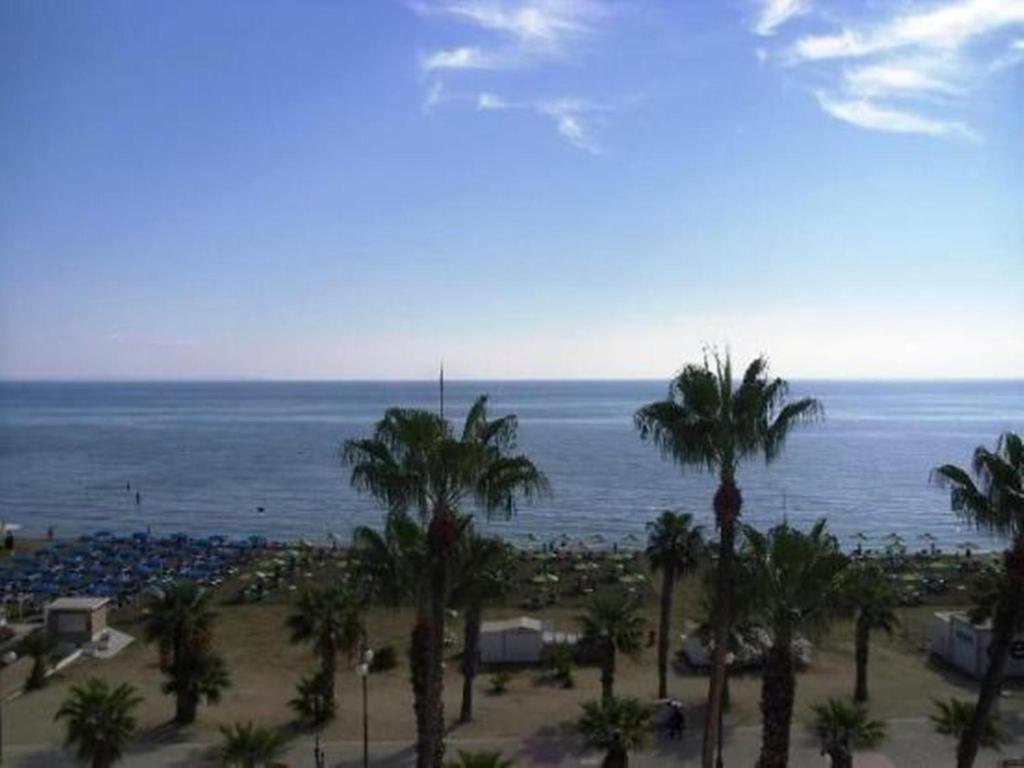 a view of a beach with palm trees and the ocean at Sunorama Beach Apartment in Larnaca
