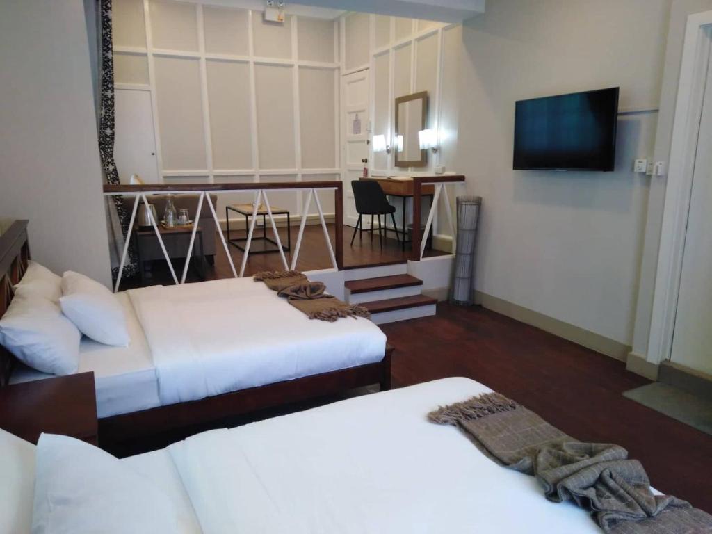 Cette chambre comprend deux lits et une télévision. dans l'établissement R Bed and Breakfast, à Baguio