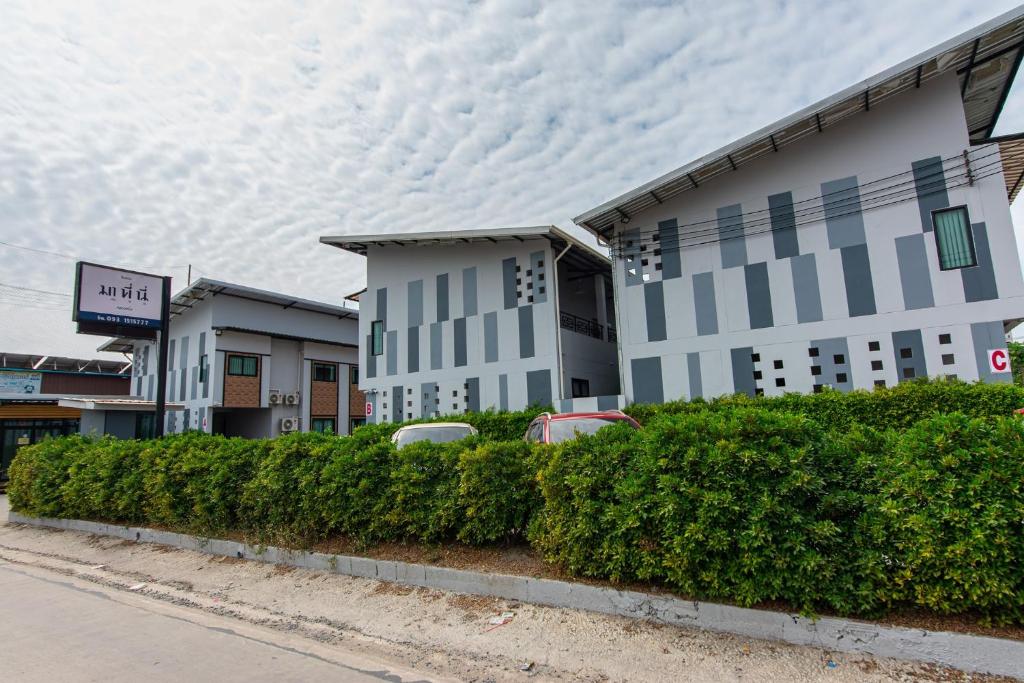 a building with cars parked in front of it at Matini Klong1 in Ban Talat Rangsit