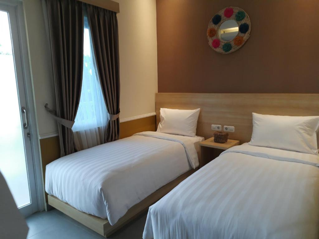 Postel nebo postele na pokoji v ubytování Americano Hotel Syariah Yogyakarta
