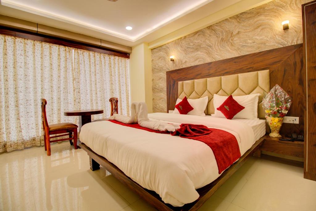 a bedroom with a large bed and a desk in it at Hotel Samaira Residency,Dombivali in Dive