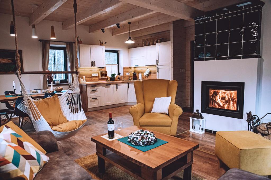 a living room with a hammock and a fireplace at Chata BlueBerry in Belá