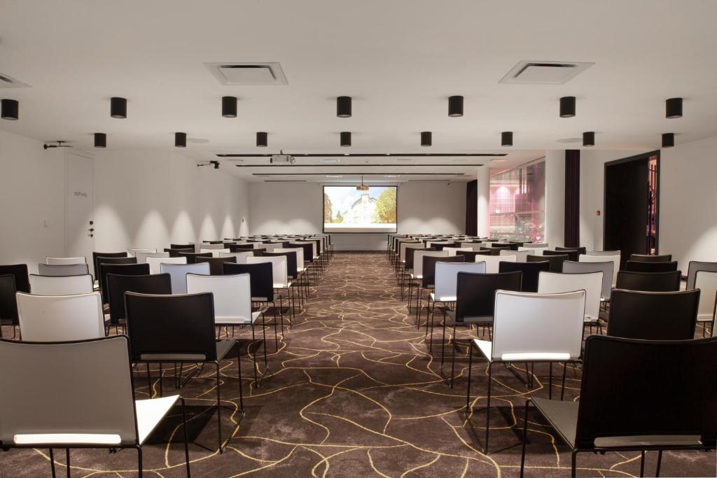 Habitación con filas de sillas y pantalla de proyección en OREA Congress Hotel Brno, en Brno