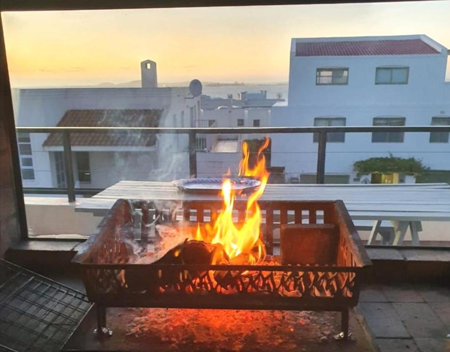 a fire pit on a balcony with flames in it at Langebaan Paradise Beach Self Catering 4 Elara in Langebaan