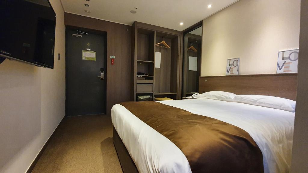Postel nebo postele na pokoji v ubytování Grandmillions Hotel Seogwipo